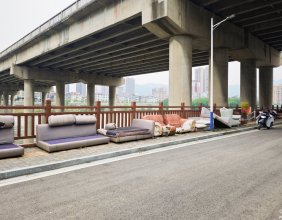 在琵琶村澧水大桥的桥下，一字排开有很多个废弃的沙发