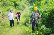 骑车路遇合堰二位村民义务砍茅草，保障渠道公路的通畅