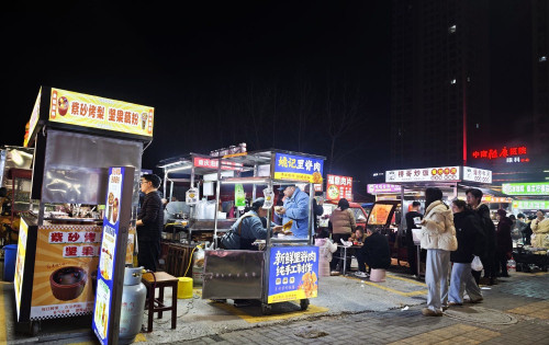 腊月二十七晚上的碧桂园桥头夜市，摊主盘得皮生意很红火