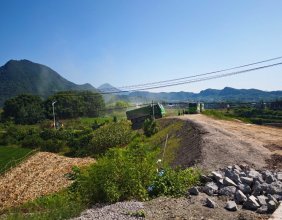 在新零溪河大桥桥头，看到数辆大车拉着砂石给支路填土