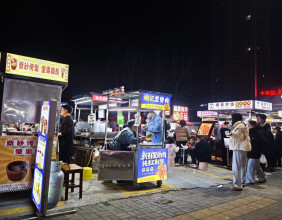 腊月二十七晚上的碧桂园桥头夜市，摊主盘得皮生意很红火